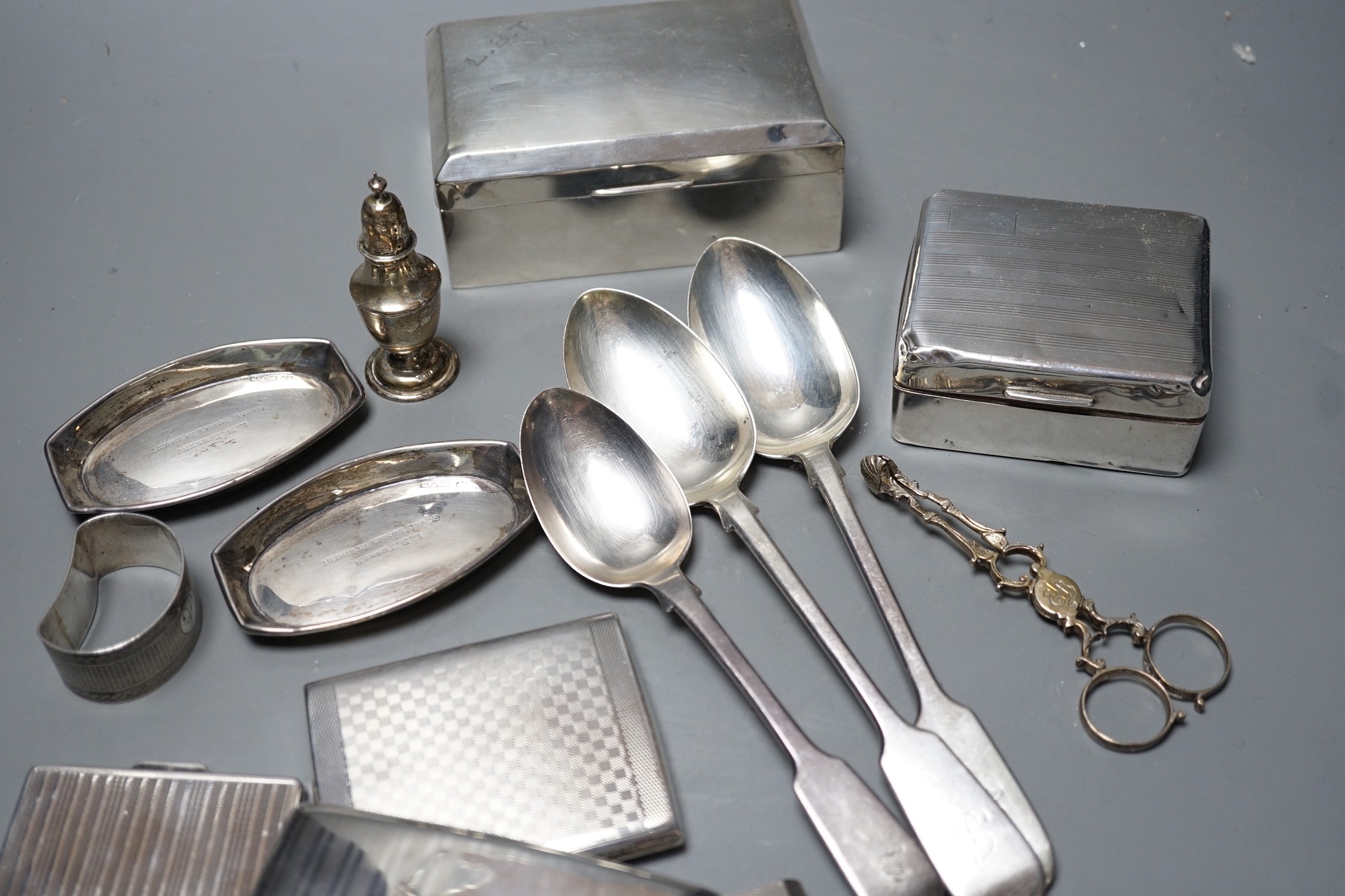 Mixed silver or white metal items including two cigarette boxes, three cigarette cases, cutlery, condiment and a napkin ring, gross
